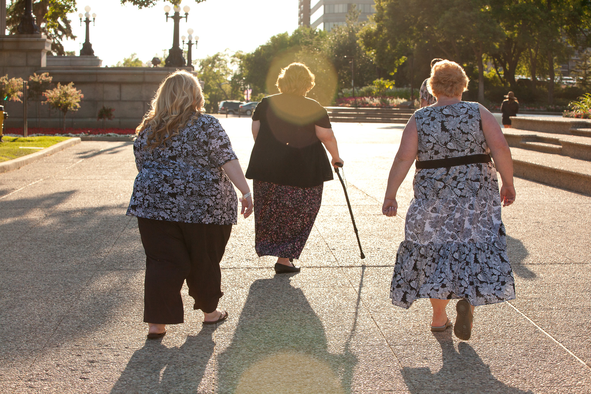 Three overweight people walking