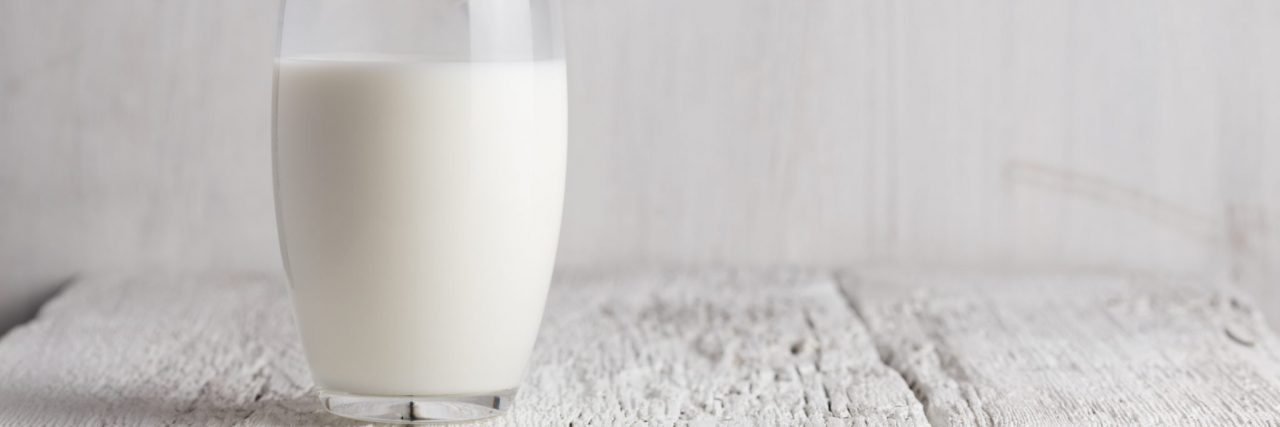 Glass of milk standing on old wooden table