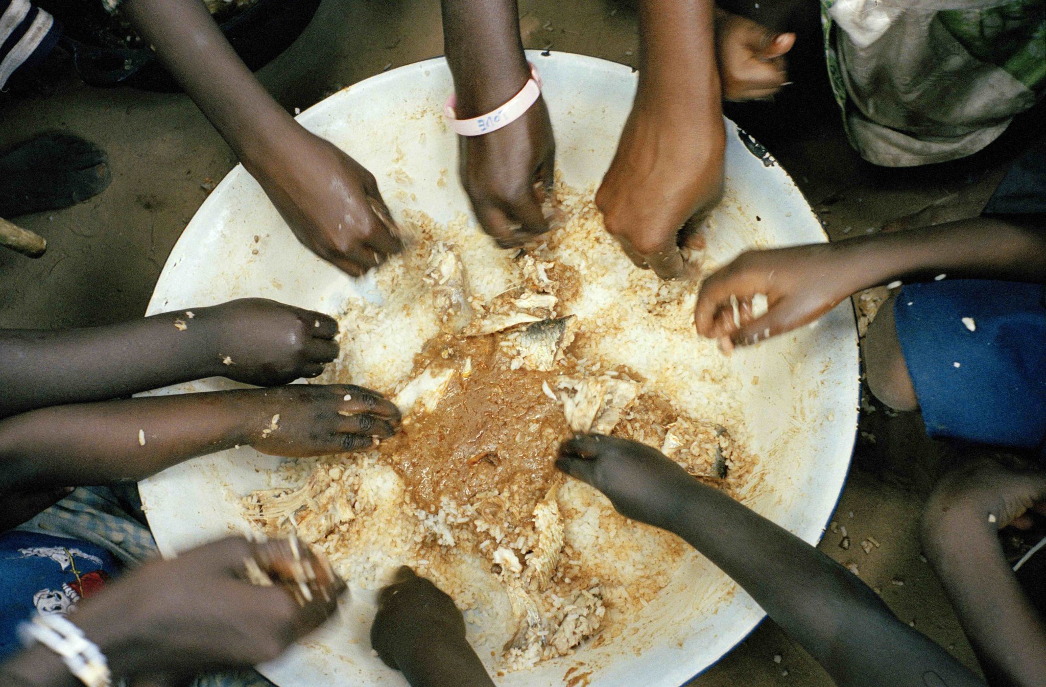 Large bowl of food with hands tucking in