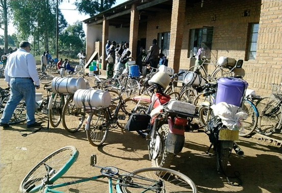 Farmers delivering milk by bicycle to Chandamale Milk Bulking Group