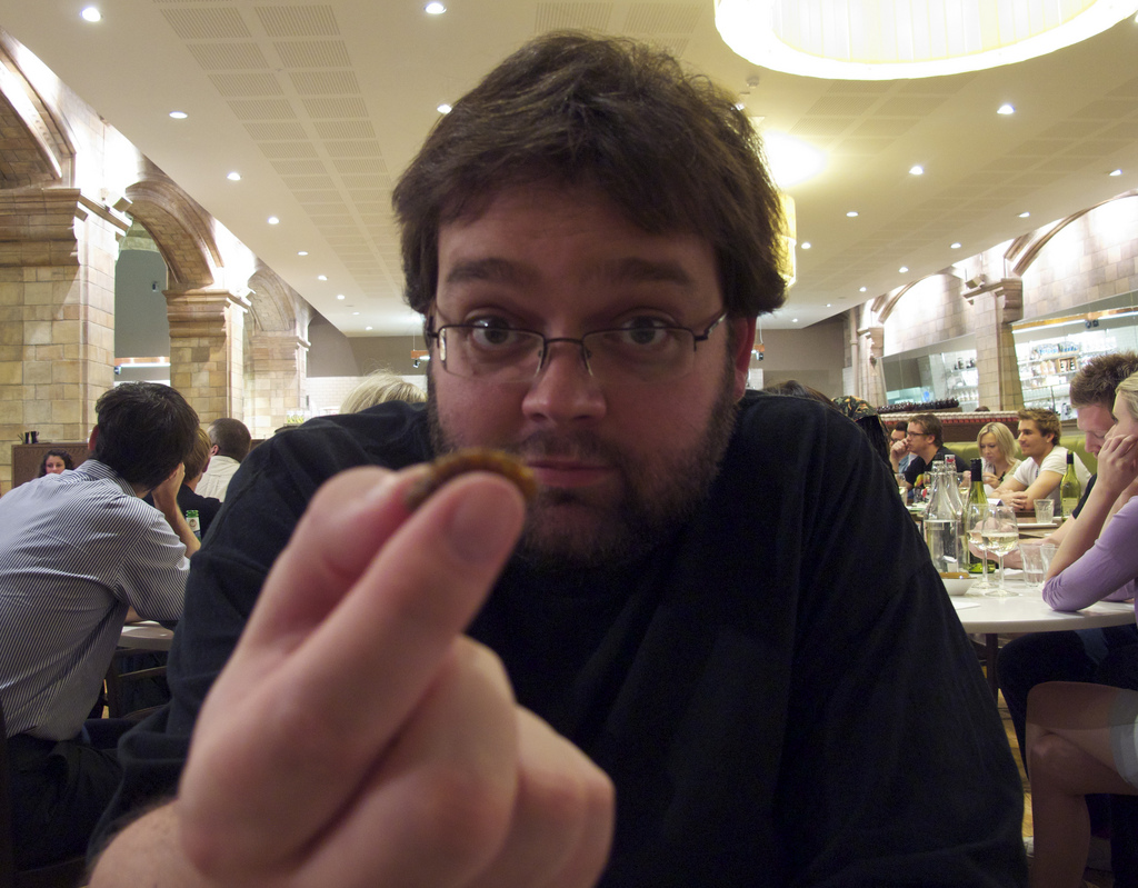 Man eating an insect in a restaurant