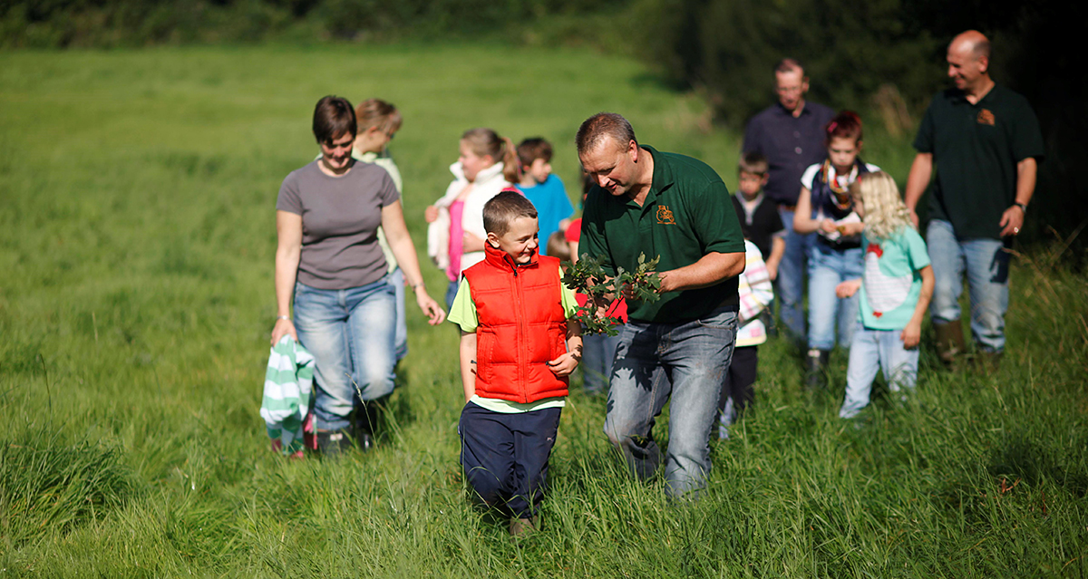 Children and adults in a field on a farm