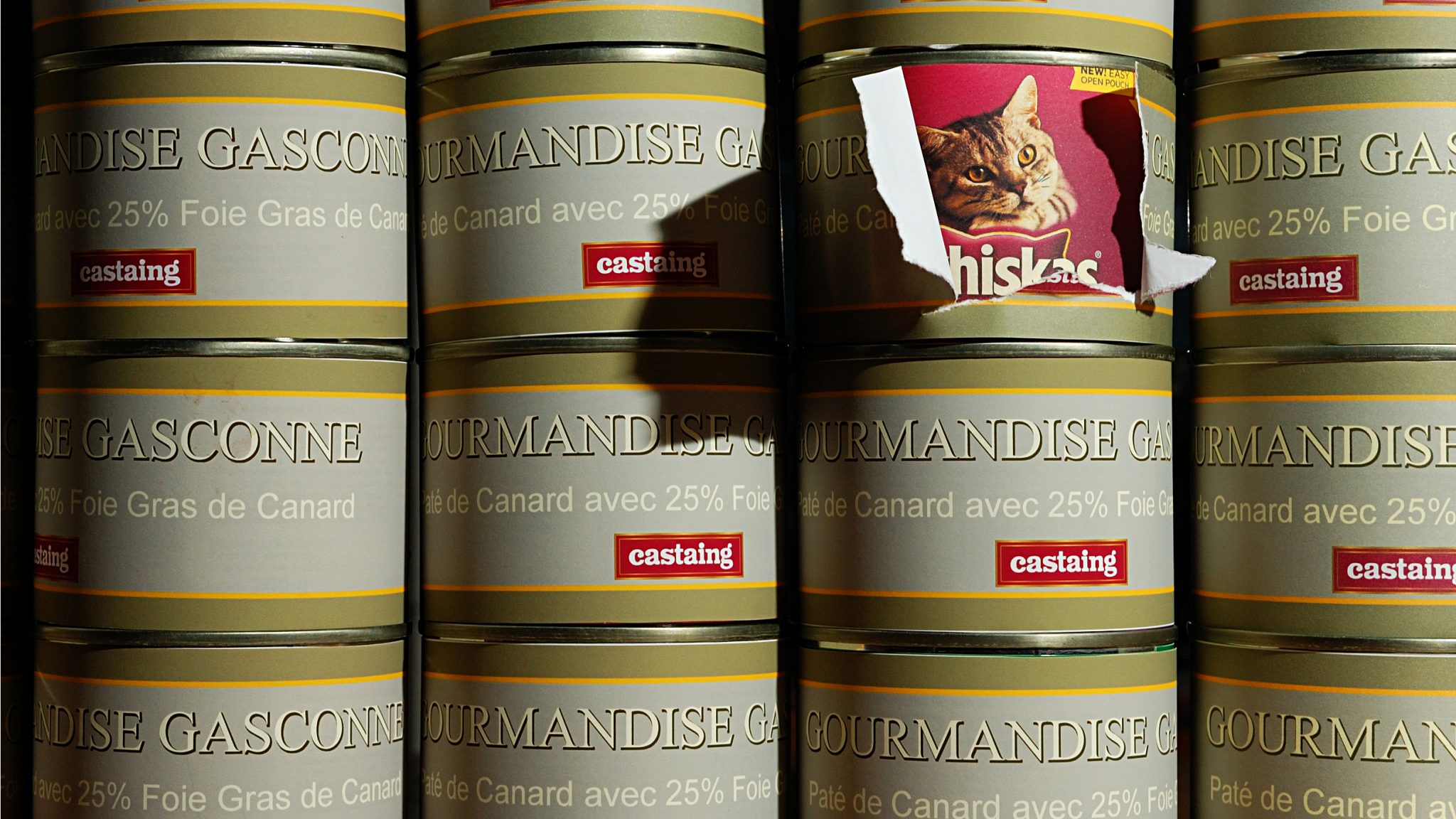 Stack of food cans with one label pealing away to reveal true contents