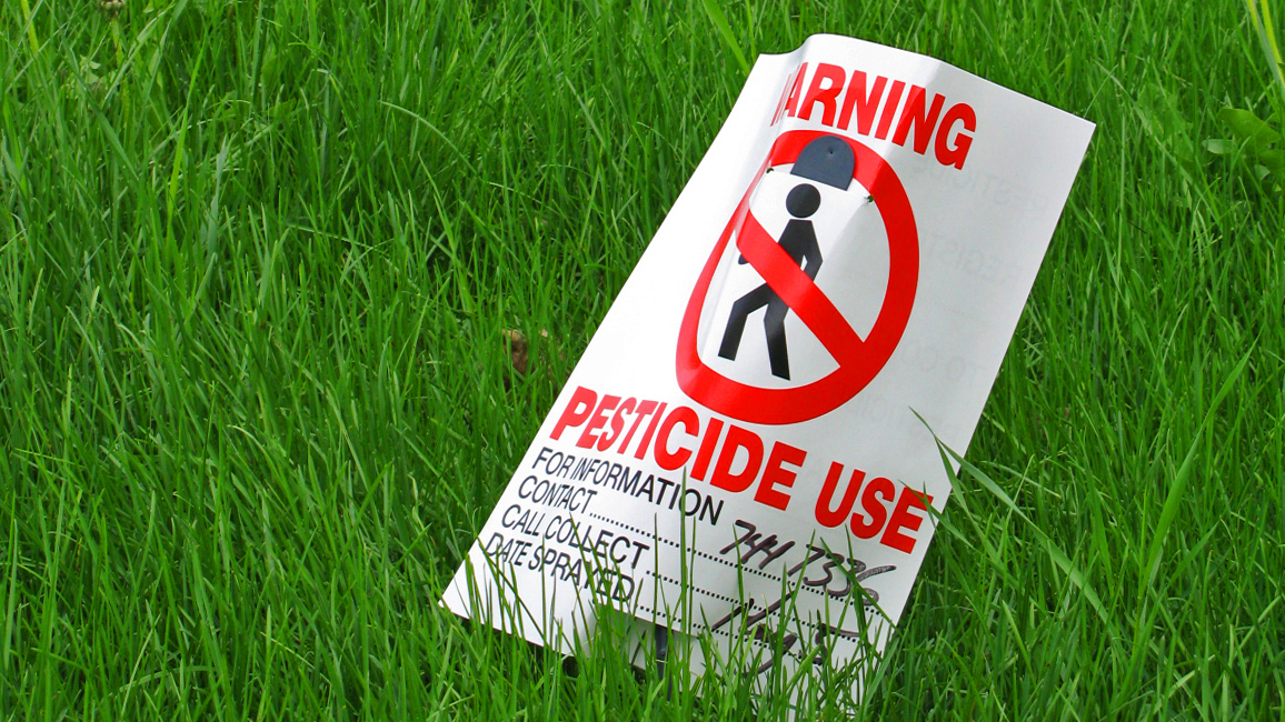 Pesticide warning sign on grass