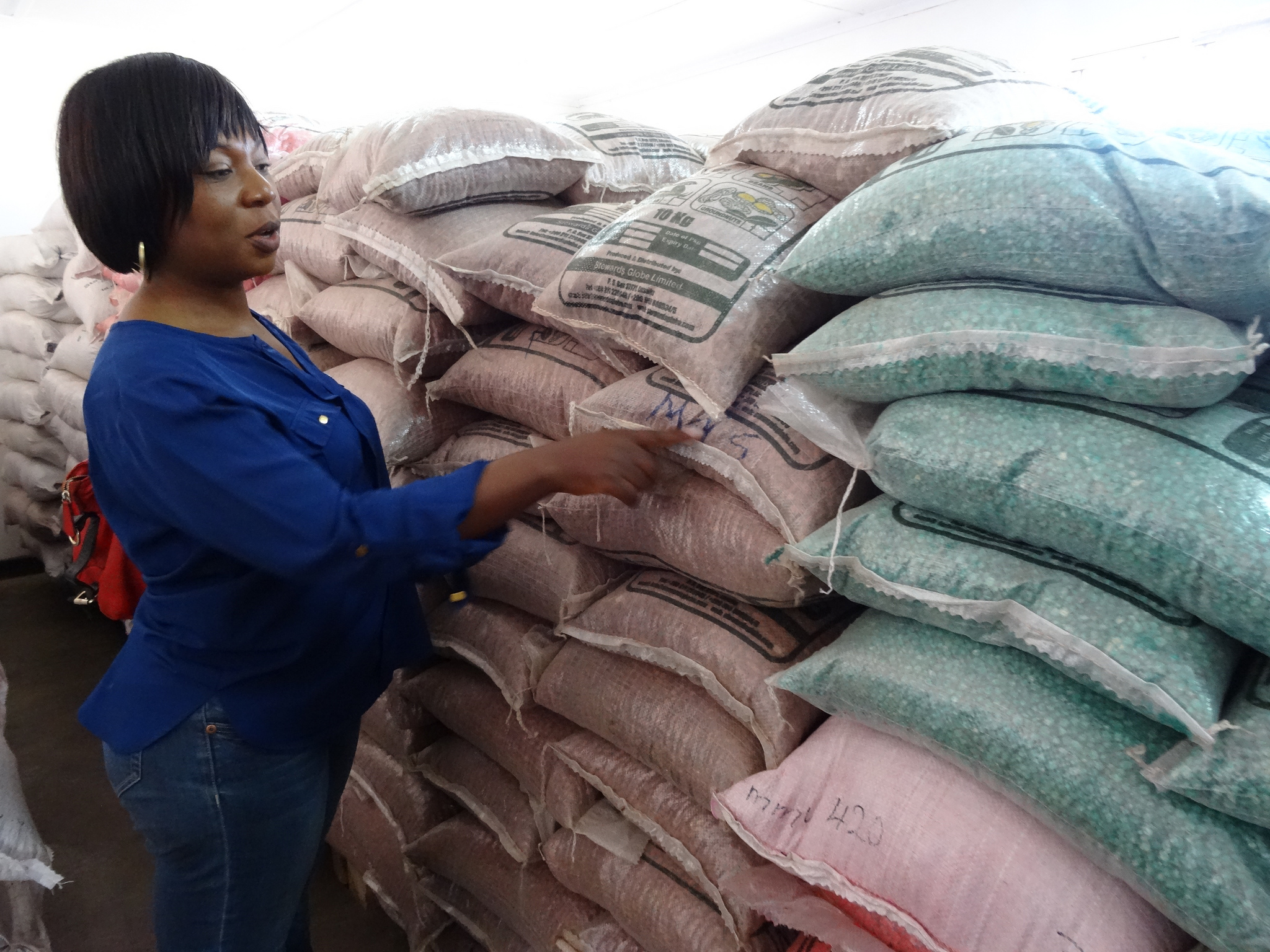 Woman from Zambia next to sacks of food