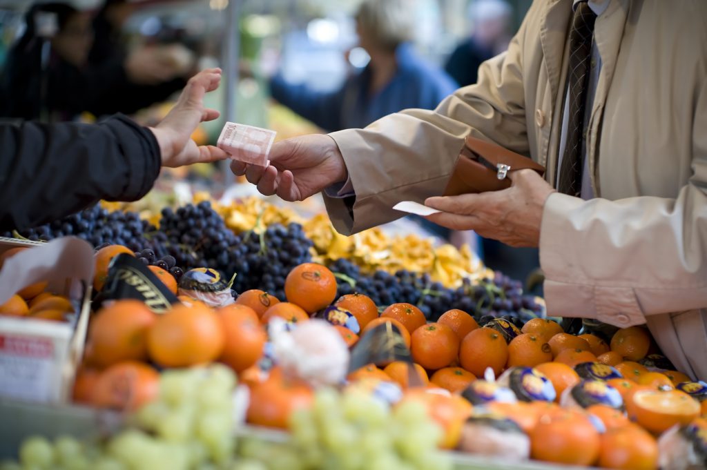 Customer paying for fruit in an outdoor market